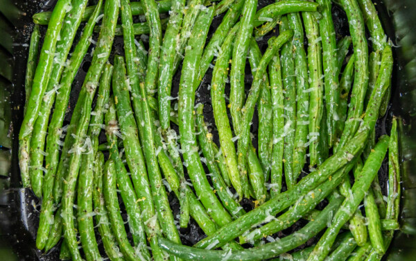 Overhead view of green beans looking into an air fryer basket.