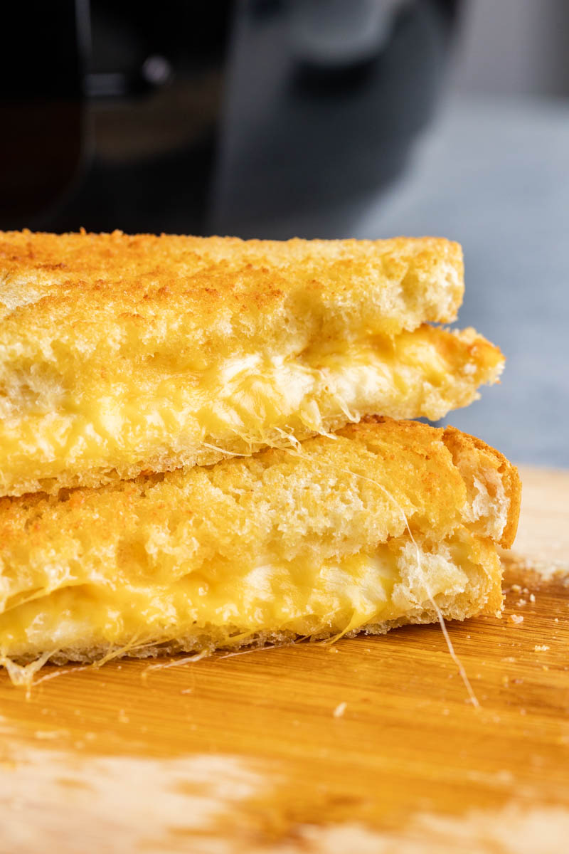 Close up view of grilled cheese sandwiches stacked on top of each other.