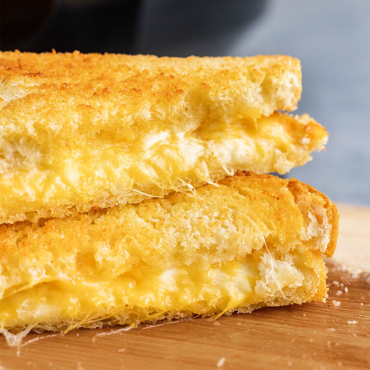 Close up view of grilled cheese sandwiches stacked on top of each other.
