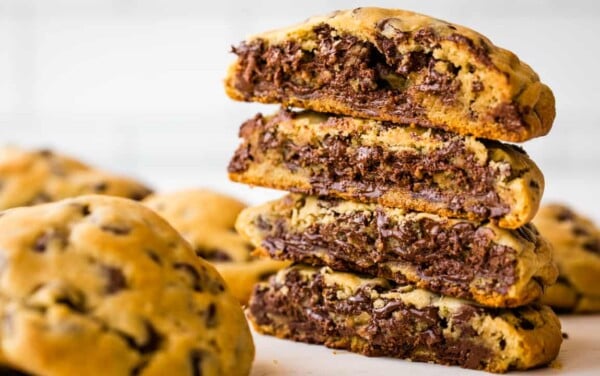 A stack of cut in halve bakery-style chocolate chip cookies.