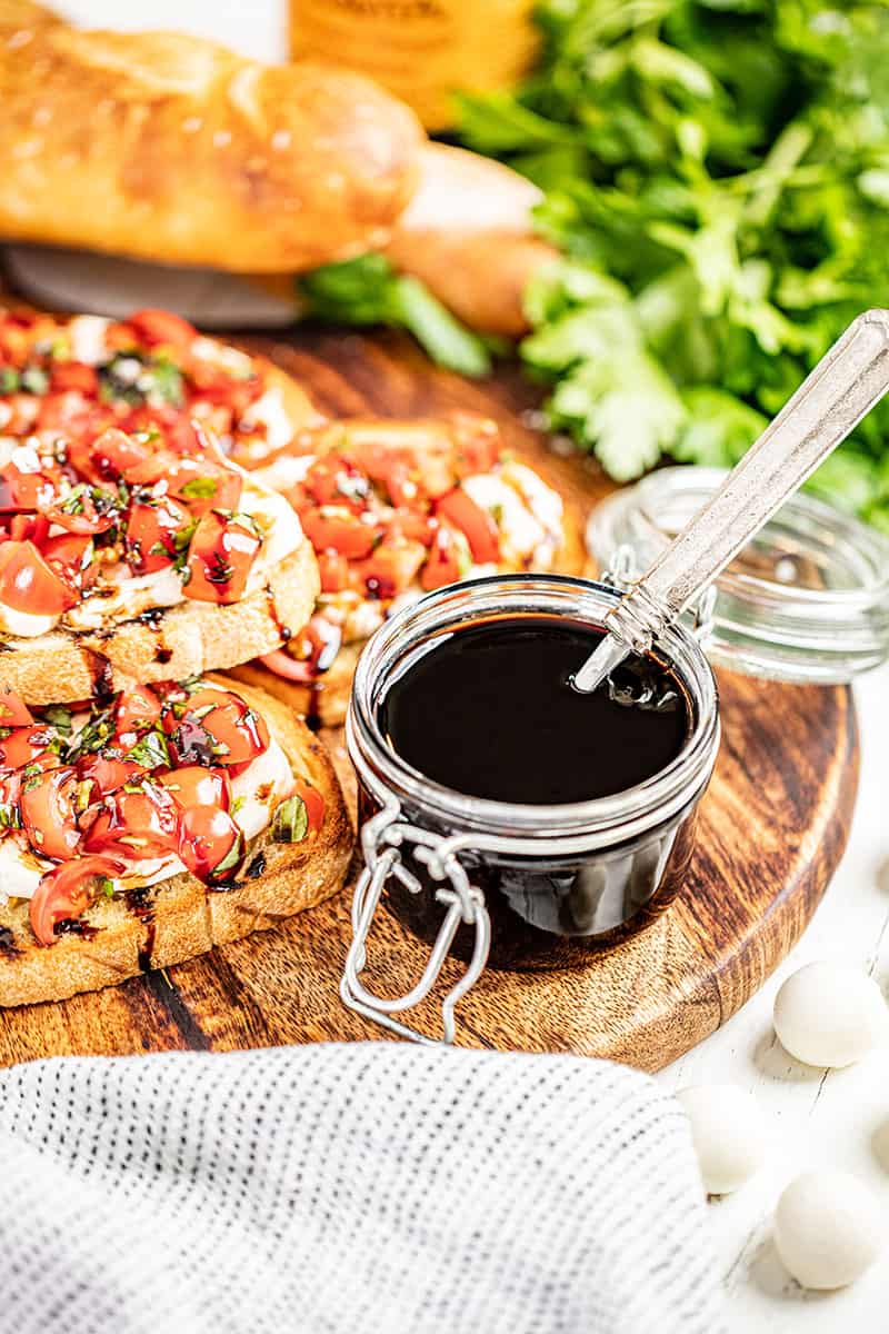 Balsamic glaze with a spoon in the jar.
