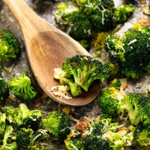 A wooden spoon with roasted broccoli.