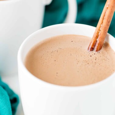 Caramelized cinnamon hot chocolate in a white mug with a cinnamon stick