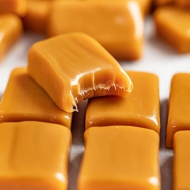 A stack of caramels with one with a bite removed.