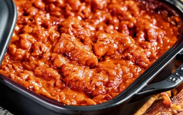 Homemade pork and beans in a square dish.