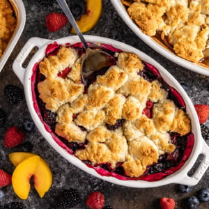 Overhead view of a berry cobbler in a white baking dish.