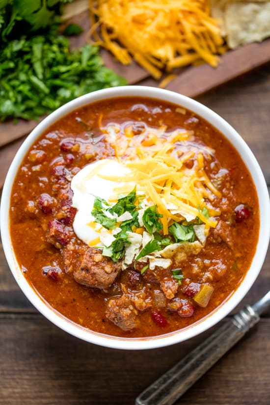A bowl of Instant Pot Chili topped with sour cream, grated cheddar cheese and cilantro