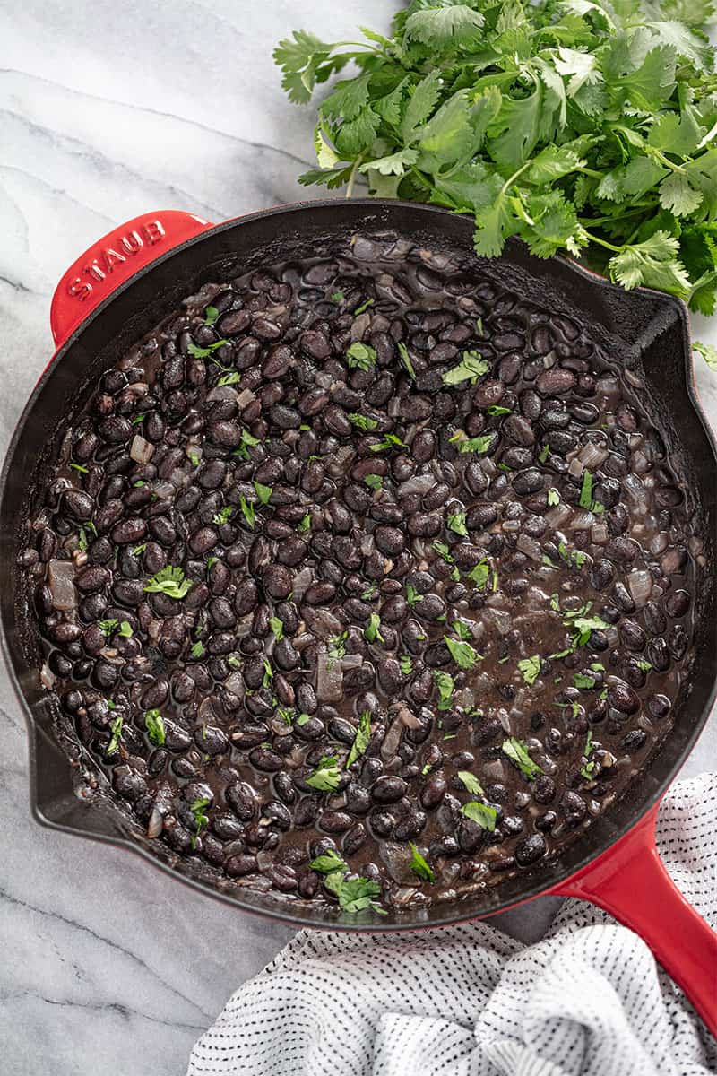Bird's eye view of Mexican Black Beans in a cast-iron skillet.
