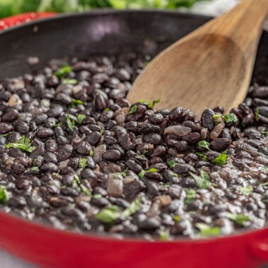 Mexican style black beans in a red skillet