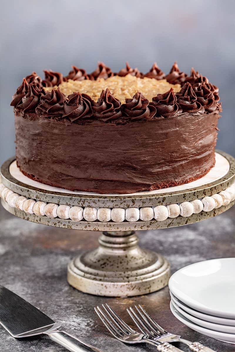 A whole German Chocolate Cake on a cake stand.