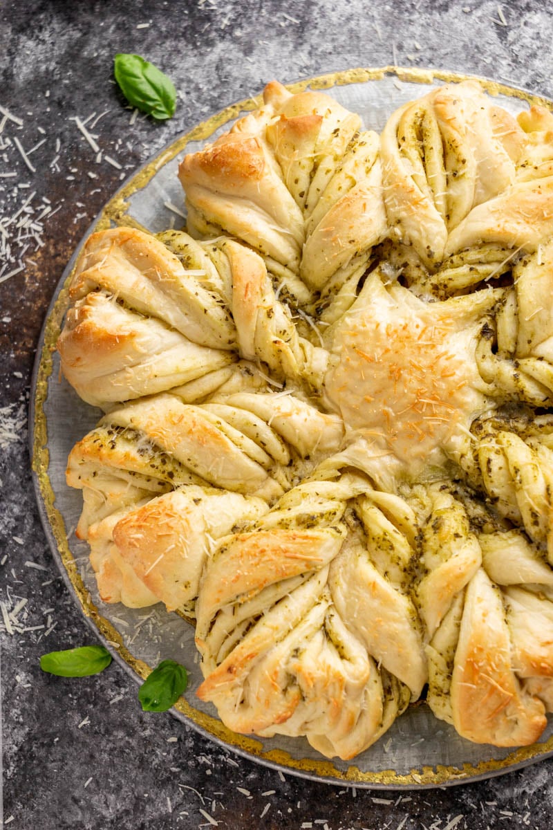 Overhead view of pesto parmesan star bread on a silver platter.