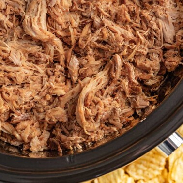 Overhead view of honey chipotle pulled pork in a slow cooker.