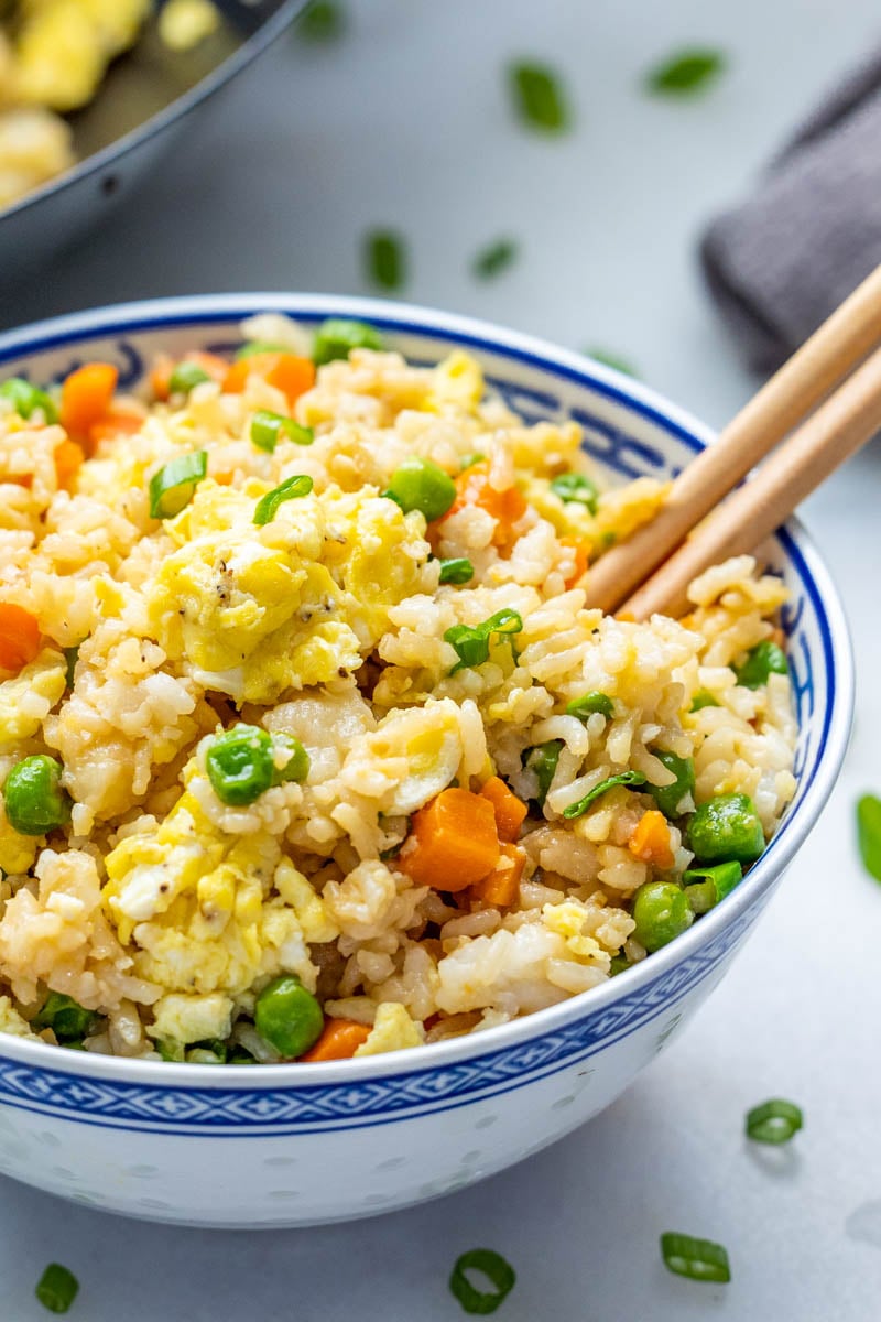 Takeout fried rice in a dinner bowl with chopsticks.