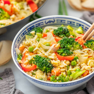 Vegetable fried rice in a bowl with chopsticks.